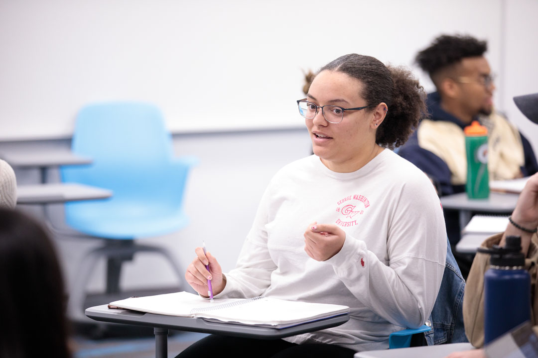 A student speaking during a group work exercise in a classroom