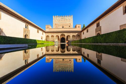 View of the Alhambra reflected in a pool in a clear day